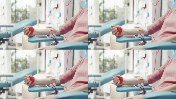 女性献血者的手的特写镜头。妇女挤压心形红球，将血液通过管道泵入袋中。捐赠给有妊娠并发症的妇女。