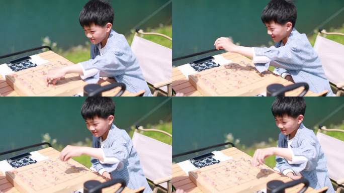 在湖边下棋的中国男孩