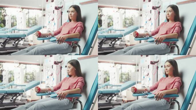 白人妇女在光明医院为有需要的人献血。女性献血者挤压心形红球，将血液通过管道泵入袋中。为抗癌儿童捐款。