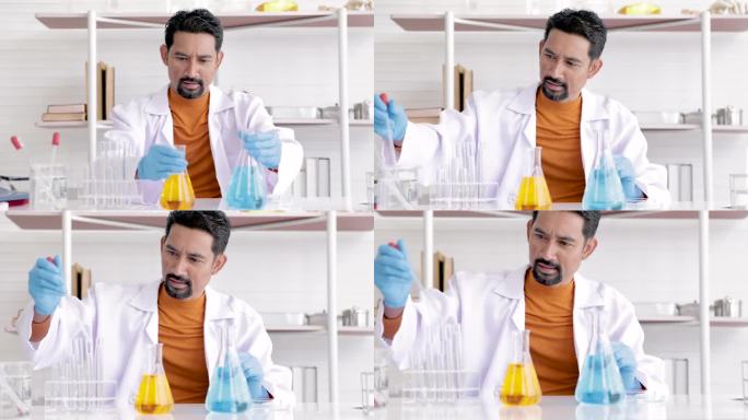 亚洲男科学家戴着蓝色手套，在混合实验室化学物质前安全进入科学室，在实验室玻璃管中分析液体生物化学物质