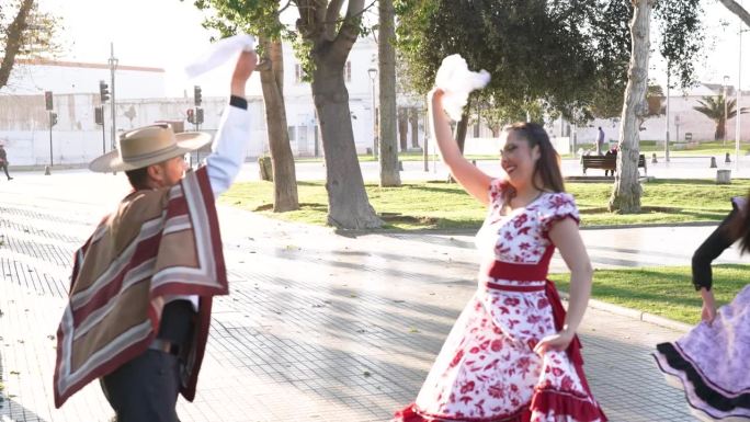 拉丁美洲年轻的情侣们穿着花衣跳着民间传说中的cueca舞