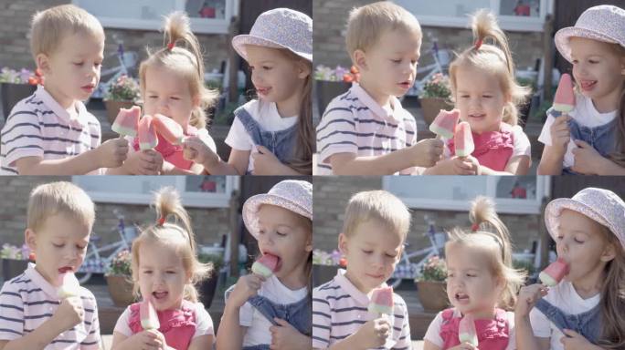 三个可爱的小孩在享用美味的甜筒冰淇淋。吃西瓜冰棒的孩子。孩子们兄弟姐妹们在家庭花园吃糖果。暑假炎热的