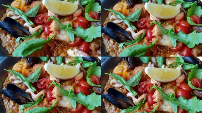 海鲜饭海鲜西班牙食物米饭烤肌肉鱿鱼鱼和虾浇上番茄和柠檬4k