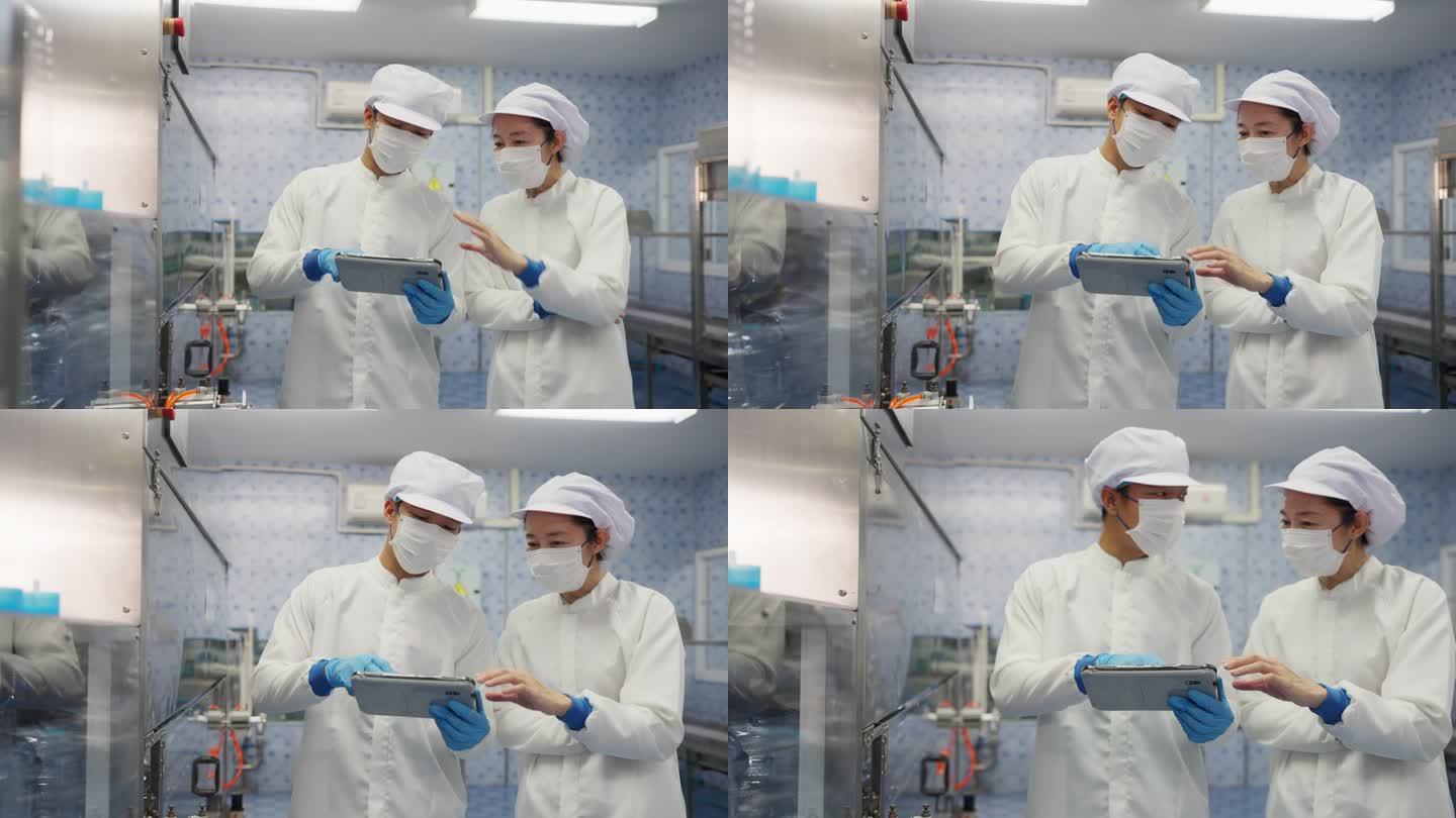 两名专业工程师穿着实验室工作服和手套，用平板电脑控制自动化灌装线系统，具有无与伦比的精度和专业知识。