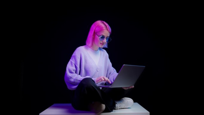 使用黑色背景笔记本电脑的创意女性，现代青年，内容用户