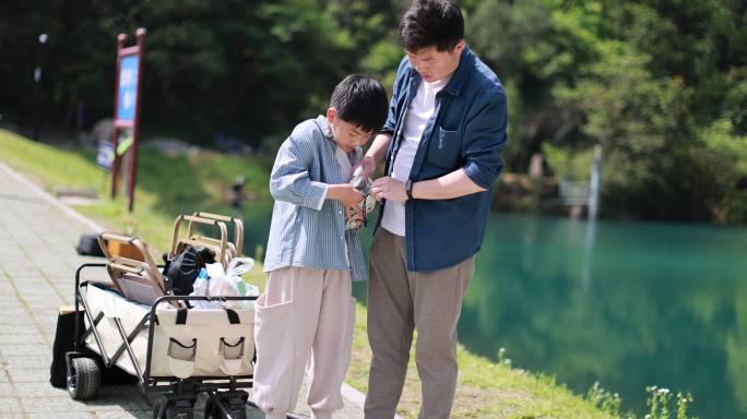 一对父子正在湖边扎帐篷 露营 踏青