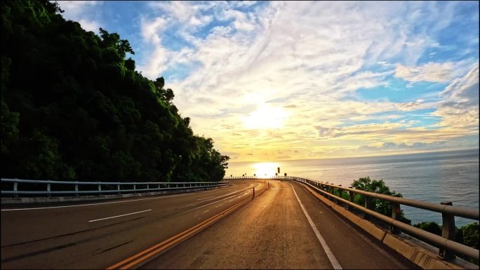 在台湾南部沿海高速公路上，开车进入日出。