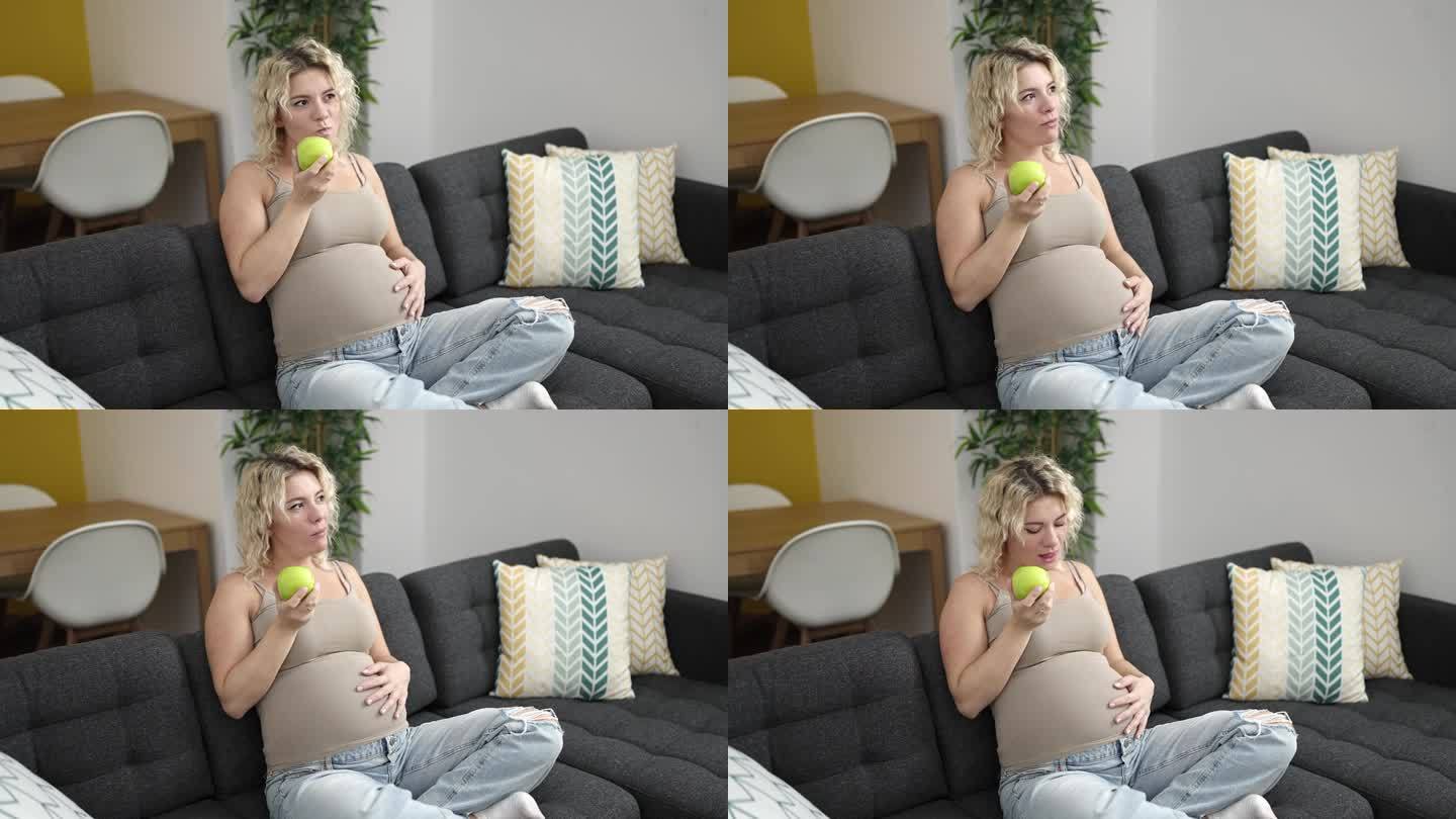 年轻孕妇在家吃苹果摸肚子