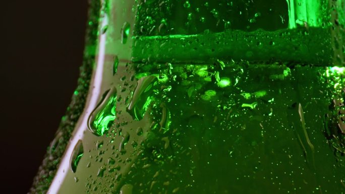 玻璃啤酒瓶里的酒精饮料。在抽象现代的室内派对上喝美味的气泡饮料。清晰的宏观视角的湿纹理和美丽的表面颜