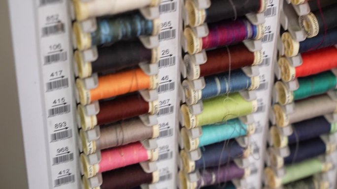 裁缝车间特殊垂直板上的彩色棉线线轴，专业缝纫机的线卷，纺织工业的织物线，针线概念
