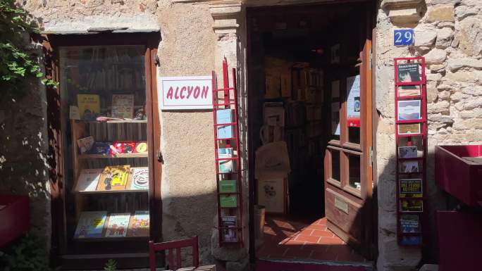 法国小镇斑驳墙面的书店门口陈列了很多书