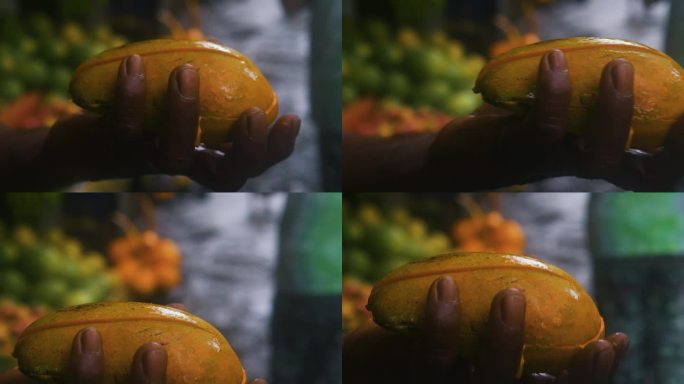 街头市场上，一名亚洲小贩手里拿着芒果片，向顾客兜售。