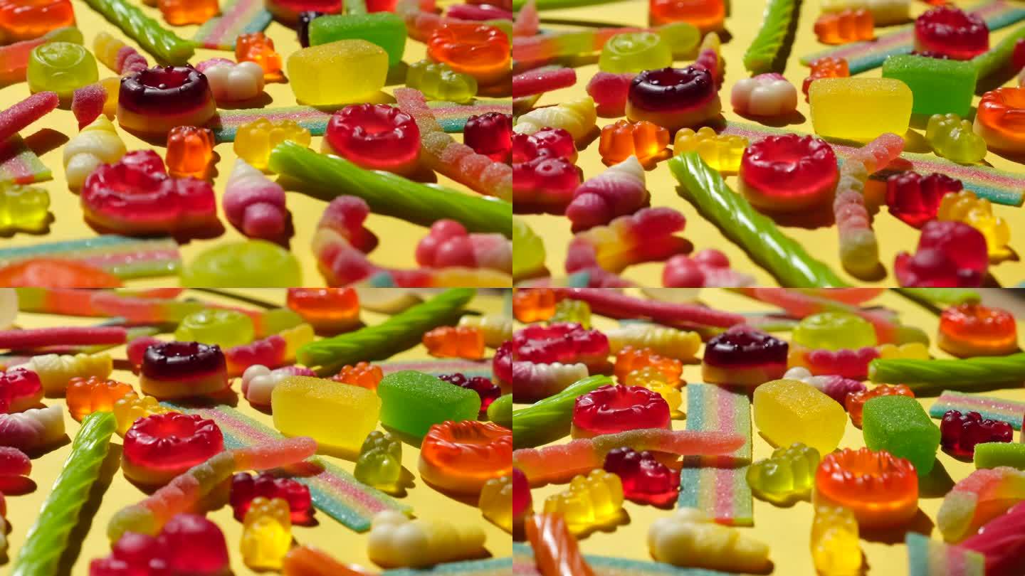 旋转背景的各种果冻糖果，熊，甜甜圈，糖果，糖果，糖霜，近距离俯瞰概念生日聚会或庆祝活动