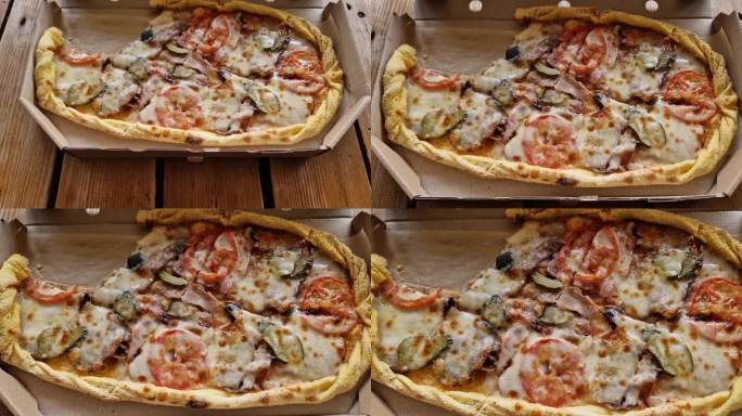 部分披萨与不同的肉在打开纸板箱