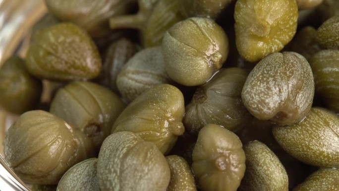 腌制的刺山柑在宏观上旋转。制作辣酱、鞑靼或沙拉的配料