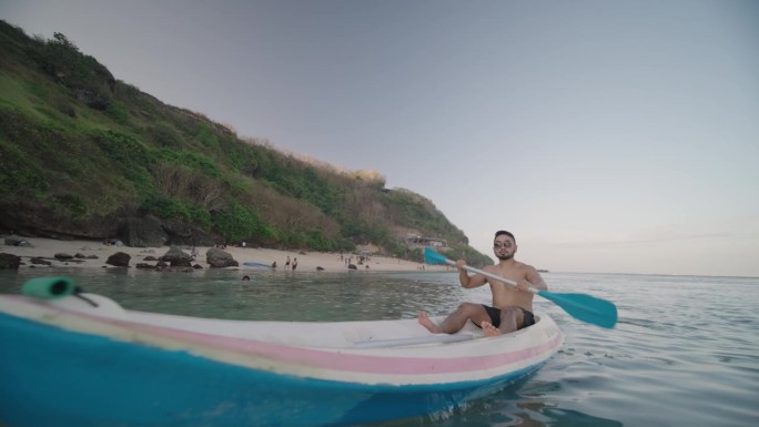印度尼西亚男子划独木舟在古农帕扬海滩，巴厘岛，印度尼西亚慢动作
