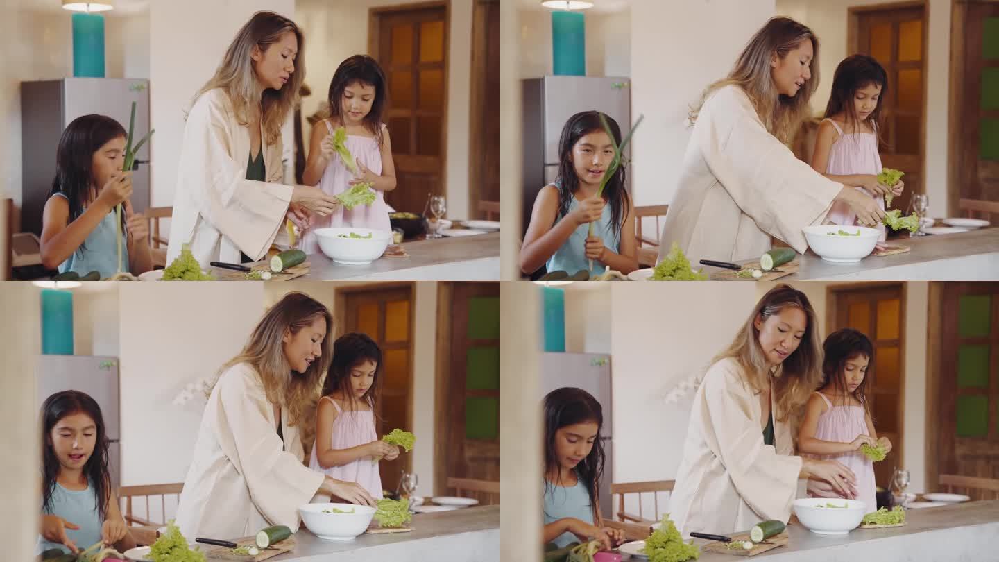 妇女和儿童在家庭厨房烹饪食物的幸福家庭。亚洲人和小孩用盘子准备素食餐。迷人的母亲和女孩在室内制作周末