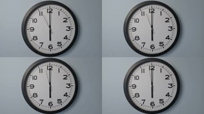 白色壁钟上的白色钟面特写，箭头显示6:00或00:00