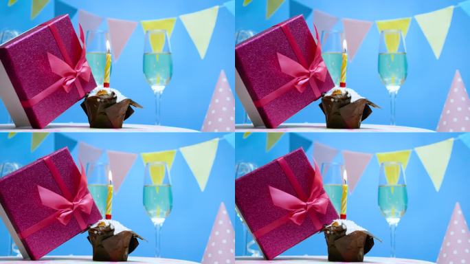 一个女人的礼盒正在纺纱，背景是生日，节日装饰为生日。周年纪念明信片。几杯香槟和一瓶香槟