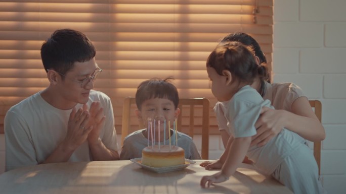 一家人在家里庆祝男孩的生日，慢镜头