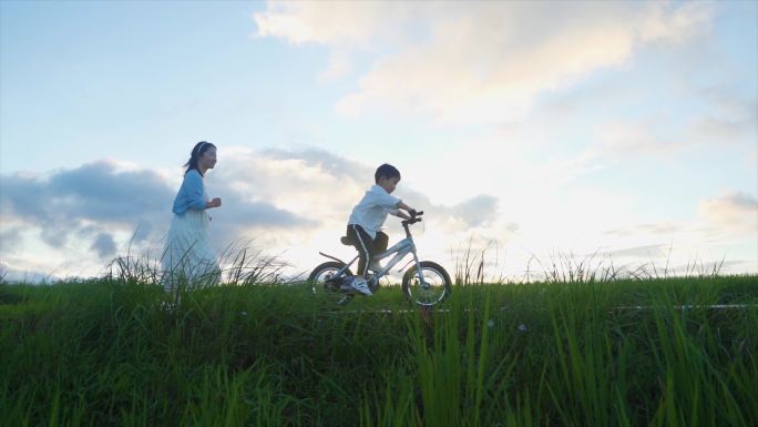 妈妈陪伴孩子户外骑自行车亲子教育儿童节