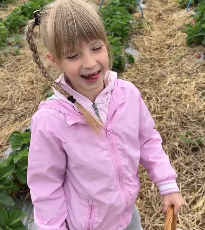微笑的女孩在农场采草莓