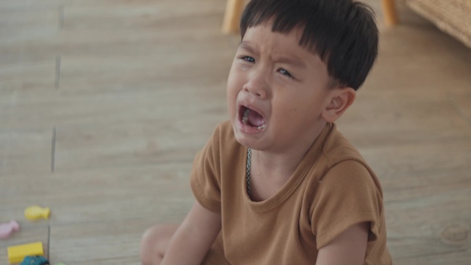 亚洲小男孩在家里的房间里哭，慢镜头