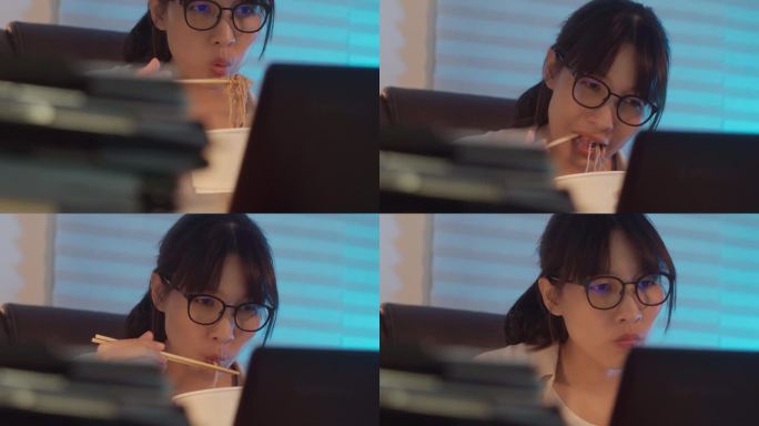 一位年轻的女商人一边在家用笔记本电脑工作一边吃方便面的4k视频片段。晚上加班