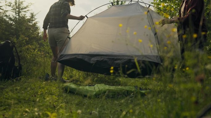一个旅游者，一个成熟的冒险家自信地在山里支起了一个帐篷过夜。美丽的