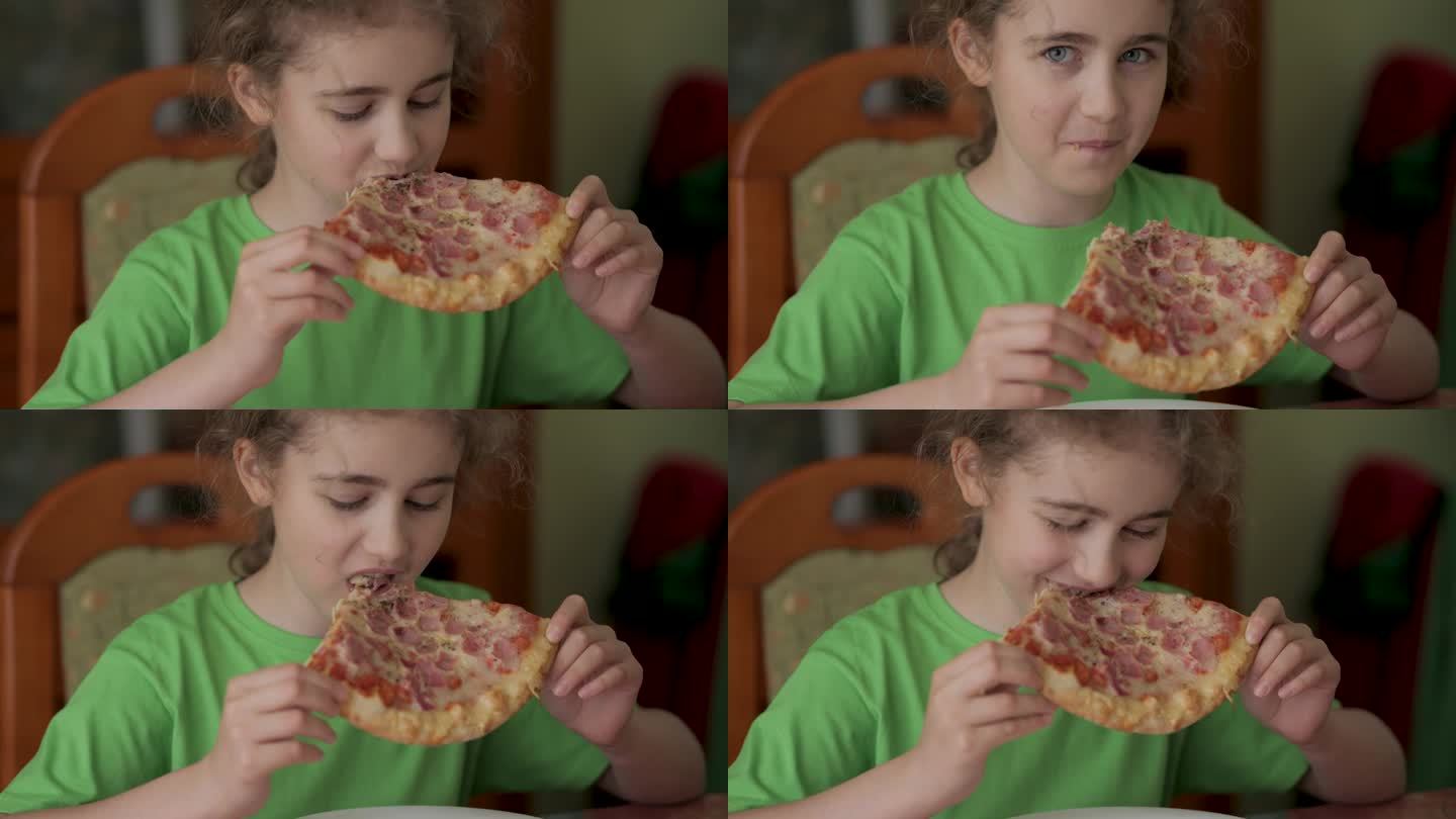 饥饿的孩子咬了一口披萨。吃披萨。饥饿的小女孩坐在家里厨房的餐桌上吃着美味的意大利披萨。不健康的营养快