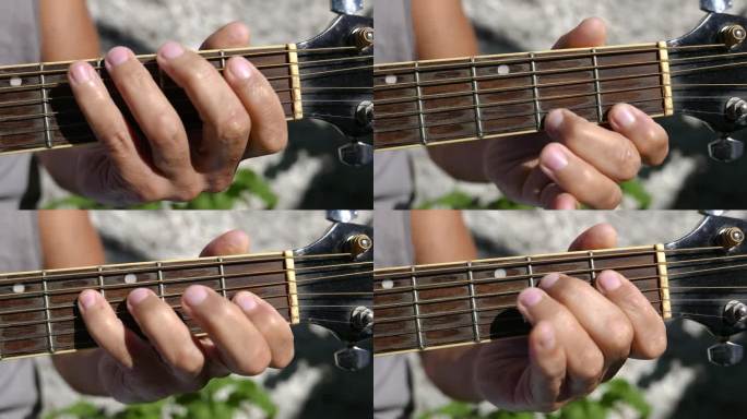 吉他手臂，指板特写镜头。有人在户外弹吉他。弹原声吉他的人。在阳光下练习吉他的人。播放音乐。拨动原声吉