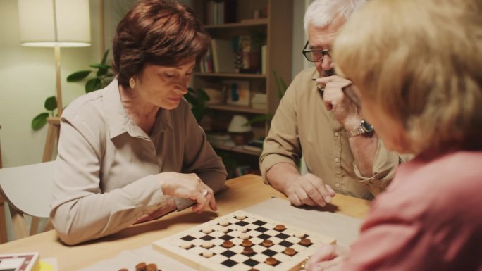 在家里玩跳棋的老年人试图赢得对方