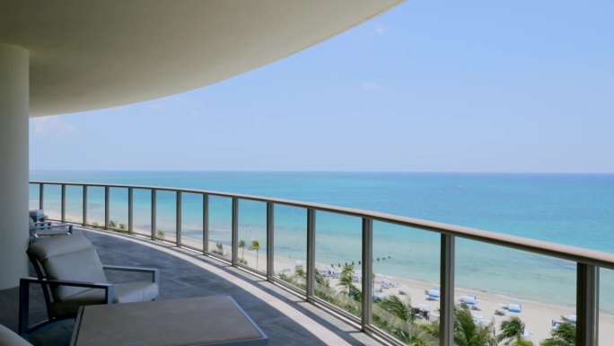 户外夏季露台与舒适的躺椅和桌子揭示风景如画的大西洋在阳光岛海滩。美丽的海滨景色和异国情调的棕榈树