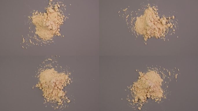 一堆大豆浓缩蛋白，从大豆中分离出来，俯视图。纯大豆分离蛋白粉末分散在灰色表面。食品添加剂，健身鸡尾酒