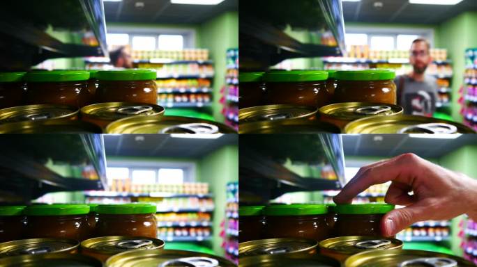 商店货架上的许多玻璃罐水果泥或罐装果酱的特写镜头，一个买家走过来拿了一个