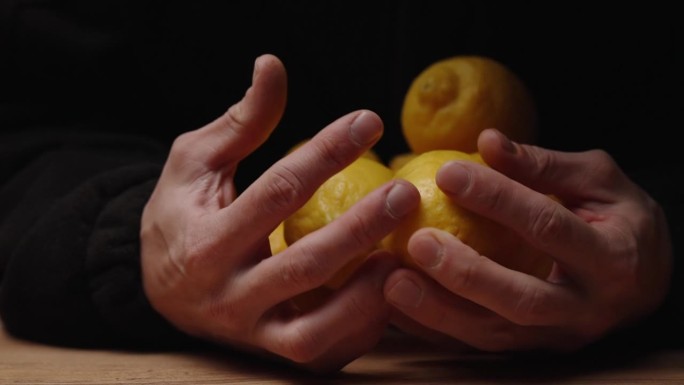 桌子上放着柠檬片，一个穿黑衣的人走过来，把所有的东西都拿在手里。缓慢的运动。