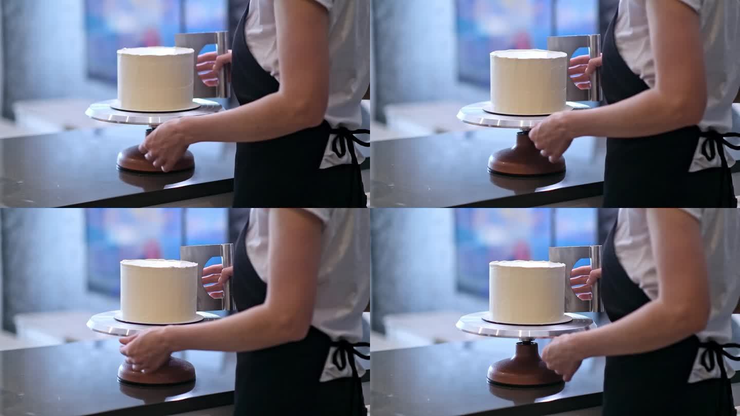专业糕饼师用油酥刮板处理烤蛋糕上的白色乳脂