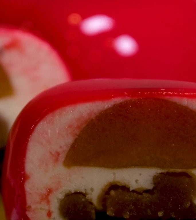 切片慕斯蛋糕红色准备斯坦尼康前镜头的现代，欧洲粉红色釉面甜点在切片。烹饪、烘焙、糕点概念