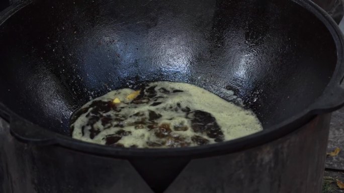 在街头美食节上，香槟酒在大锅里用油煎。油炸蘑菇