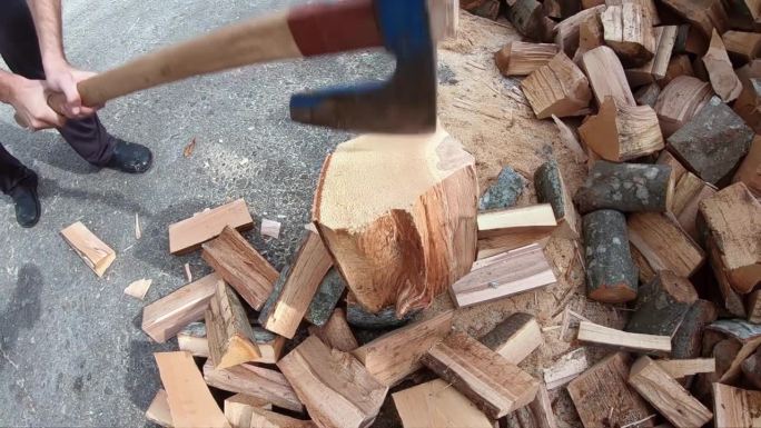 伐木工人在冬天砍柴，人们用斧头砍柴火。慢动作