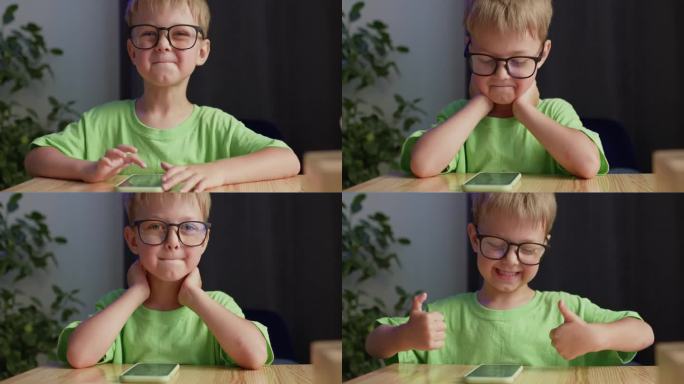 戴眼镜的快乐学龄前男孩翘起大拇指微笑
