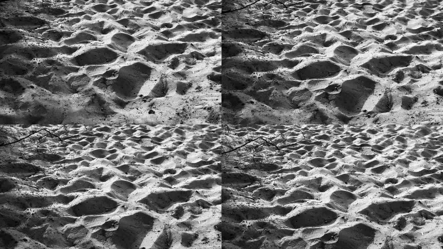 沙滩上的沙子特写黑白。夏天的时间。日光。抽象的背景。纹理自然表面。没有人。旅行的细节。波模式。自然之