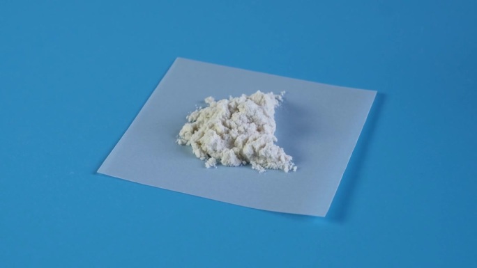 瓜尔胶粉或瓜尔胶样品在蓝色背景上顺时针旋转。瓜尔胶因其各种有趣的特性而被食品工业广泛使用。食品添加剂