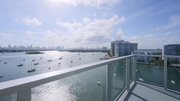在豪华高层住宅综合体的阳台上，可以看到迈阿密海滩的芙蓉花、棕榈和星岛的美景。有几十艘船的迷人港口