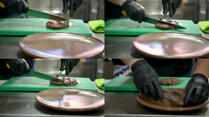 实时手持拍摄作物匿名厨师戴着黑色手套用刀切肉饼，然后把肉块夹在盘子上，而在餐厅厨房烹饪