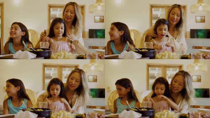 妇女和儿童在家庭餐桌上吃天然食物的幸福家庭。亚洲母亲和为有趣的孩子做的晚餐。妈妈和小女孩在客厅吃家庭