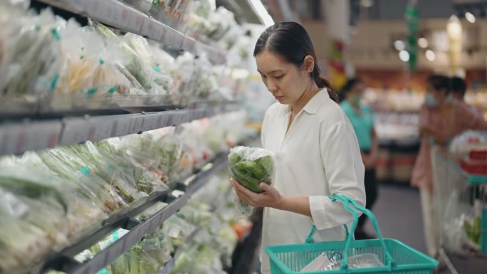 年轻女子在超市买新鲜蔬菜