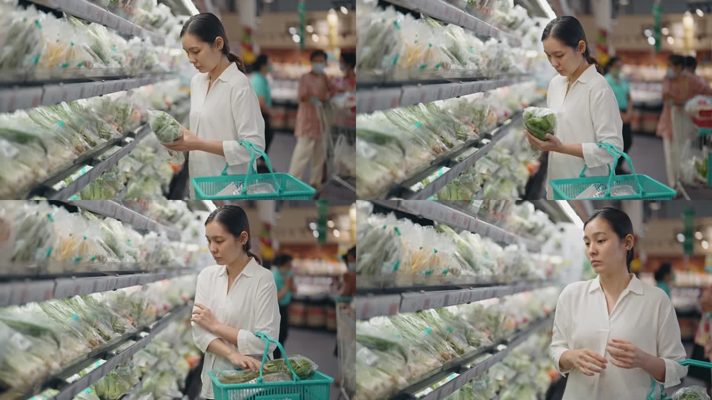 年轻女子在超市买新鲜蔬菜