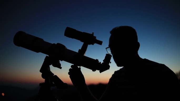 用望远镜观察星空和新月的天文学家。