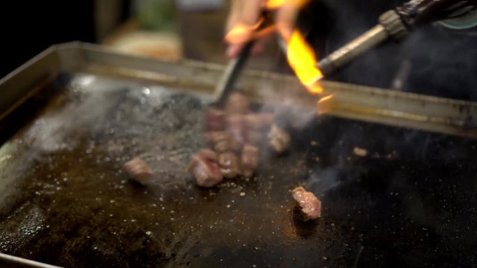街头小吃生牛肉火炬火焰烤美味的肉烧烤在亚洲夜市